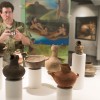 A man takes a picture of ceramic effigy art