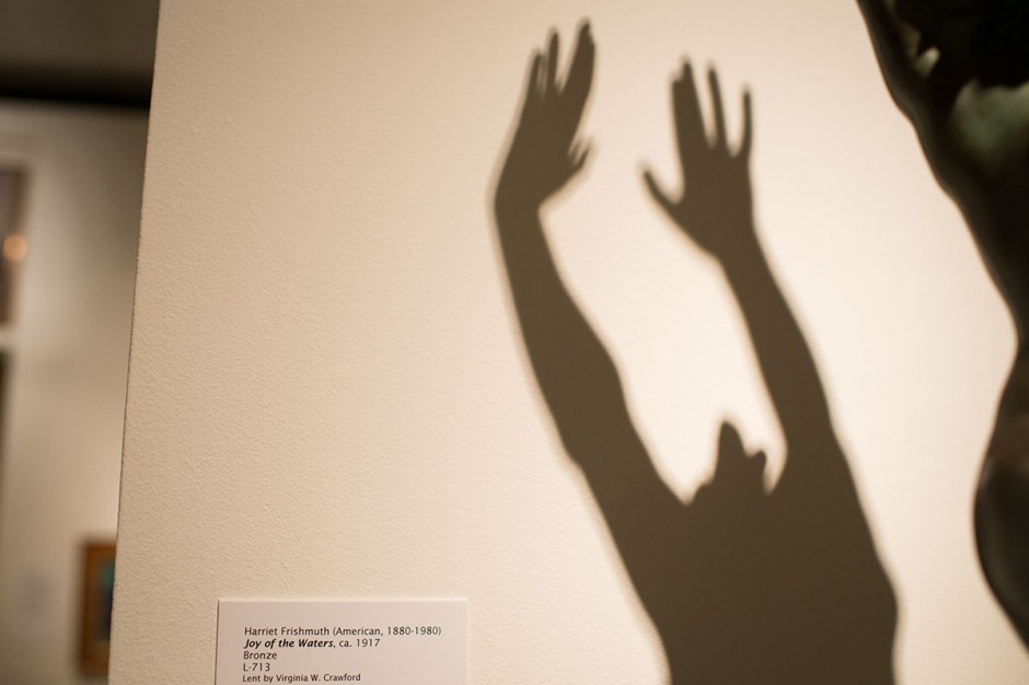 Bronze sculpture of woman with her hands in the air