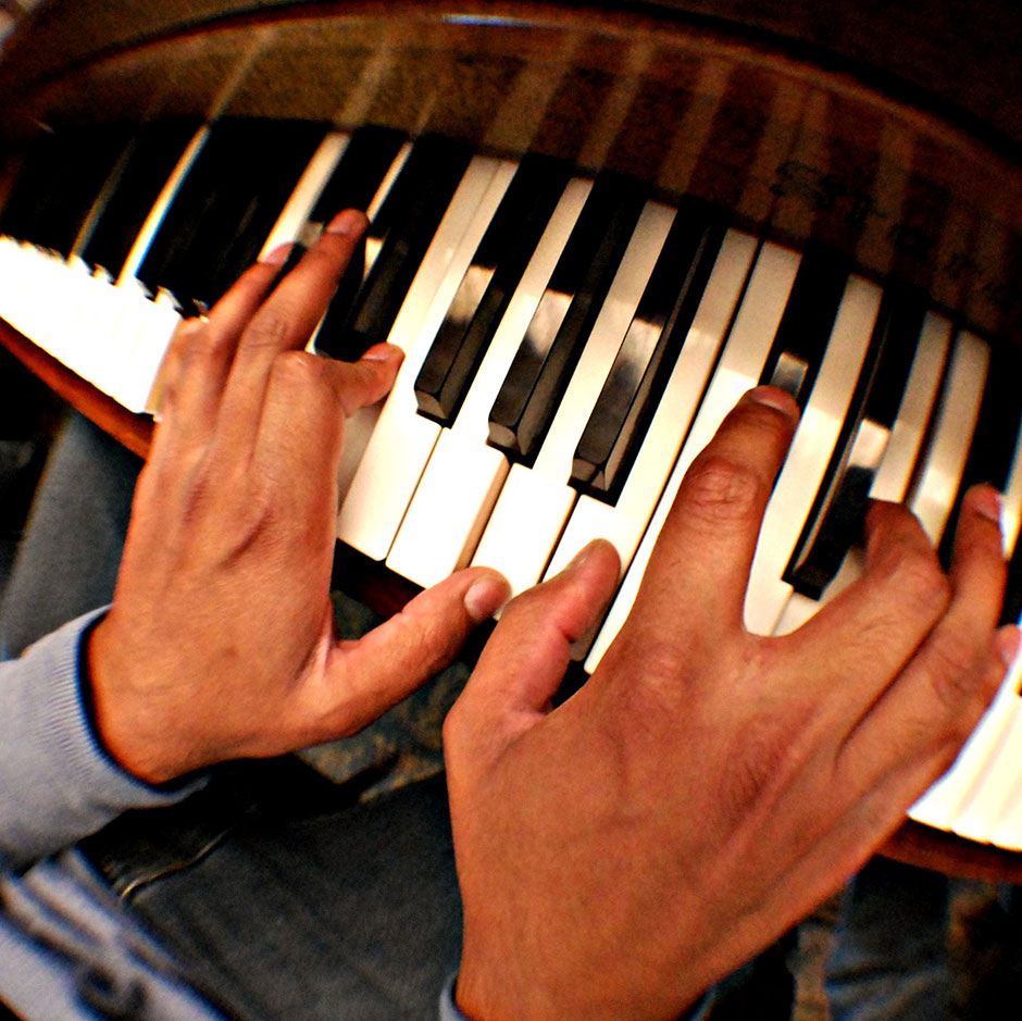 Hands on a piano keyboard