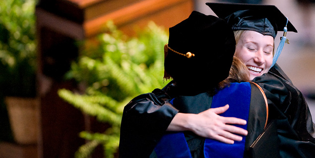 graduates hugging