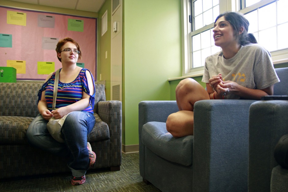 Students on chairs in a residence hall lounge.