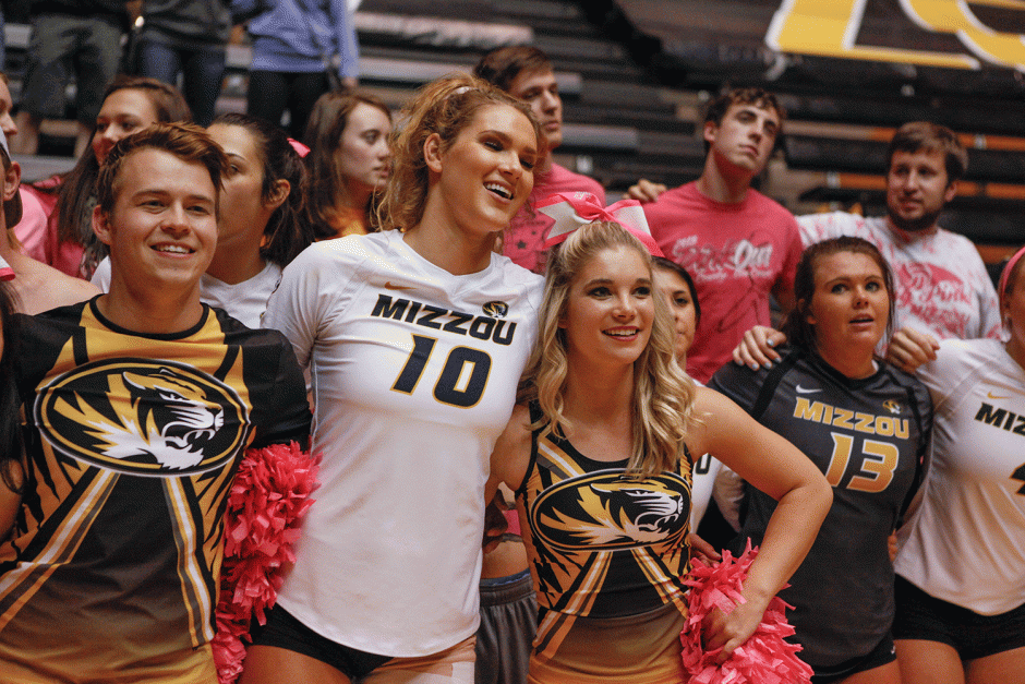 Volleyball player with cheerleaders.