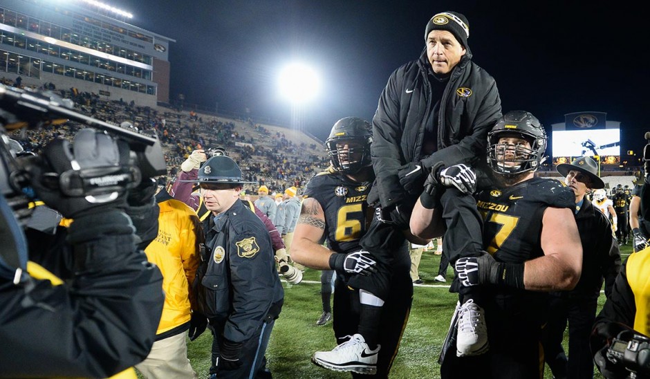 Evan Boehm, right, and Connor McGovern carry Coach Pinkel off the field. Photo by Shane Epping.