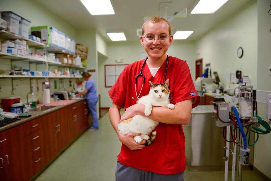 Student holding a cat in a lab