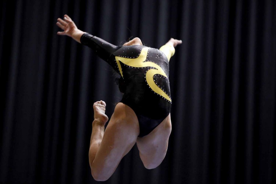 Mizzou freshman Brooke Kelly jumps into a pose during her performance on the balance beam Friday evening, Feb. 19, 2016 at the Hearnes Center.