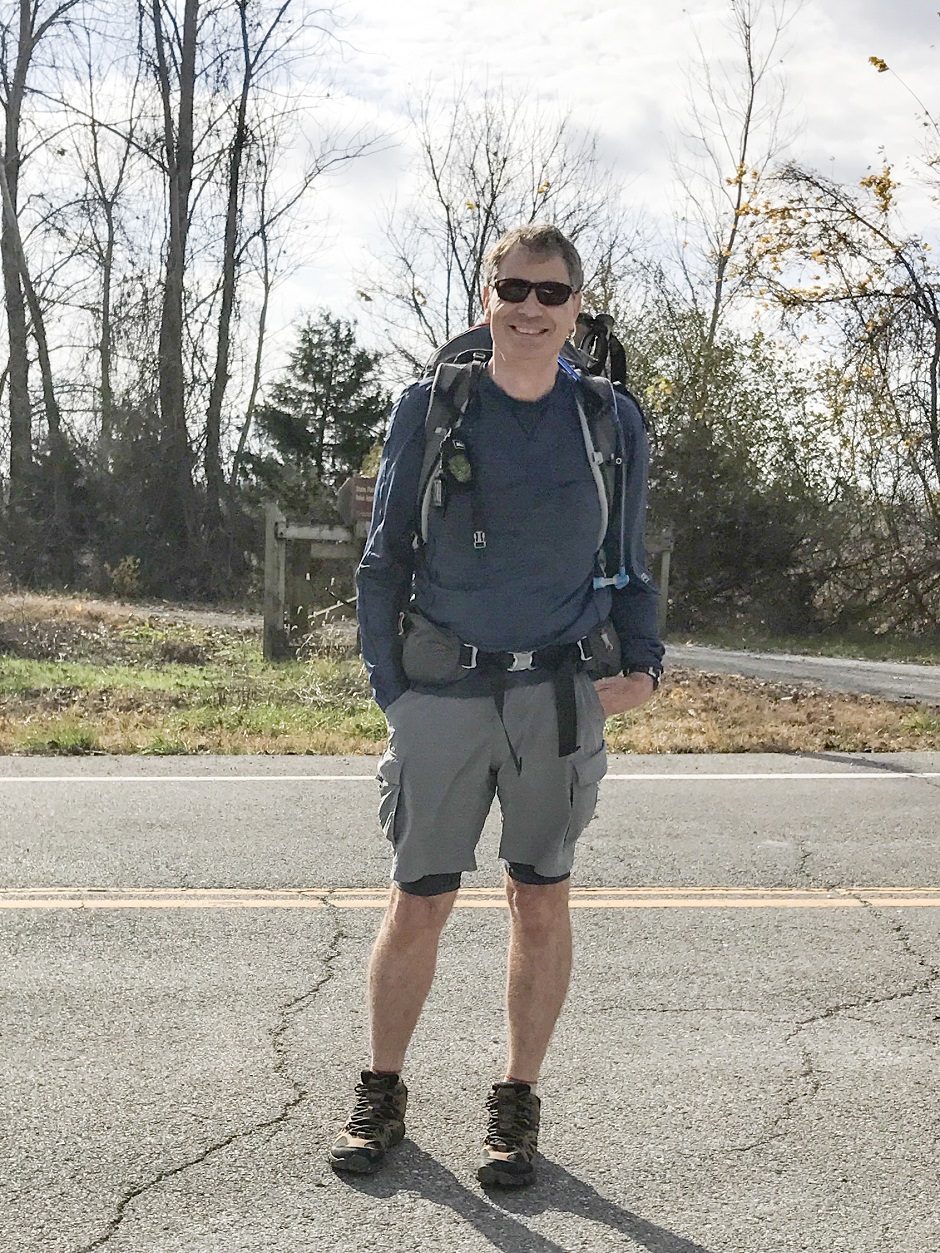 Jose Gutierrez standing on a trail wearing a backpack.