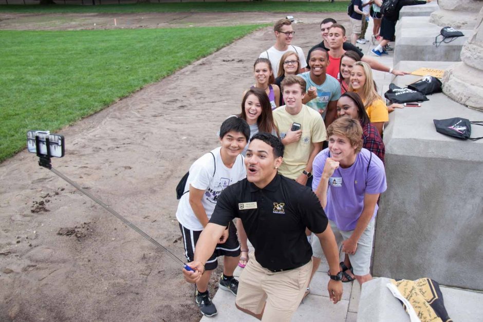 A campus Tour Team member takes a selfie with prospective students at The Columns.