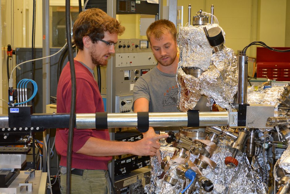 Fourth-year physics doctoral candidate Alessandro Mazza (left) works on an ultra-high vacuum called X3B2 with physics graduate student Alexander Daykin in Prof. Paul Miceli's lab.