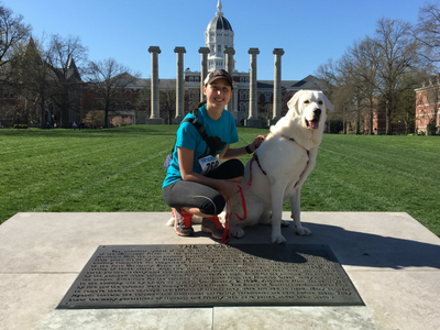 This is a picture of Megan Hicks and her dog in front of Jesse Hall and the Columns