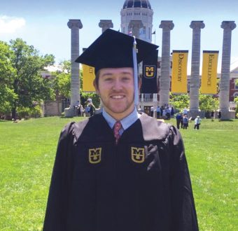 This is a picture of Ryan Platt in graduation regalia in front of Jesse Hall