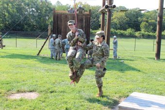 ROTC cadet Emily Campbell gets an assist from cadet Nicole Futch during training exercises.