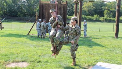 ROTC cadet Emily Campbell gets an assist from cadet Nicole Futch during training exercises.