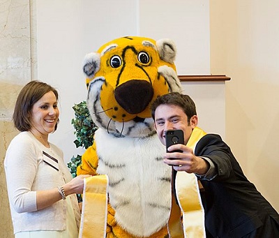 McElwain, Truman the Tiger and a Mizzou student model the Team Mizzou sashes worn during commencement