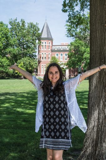 This is a picture of Dina Ahmed standing on the Quad with her arms outreached