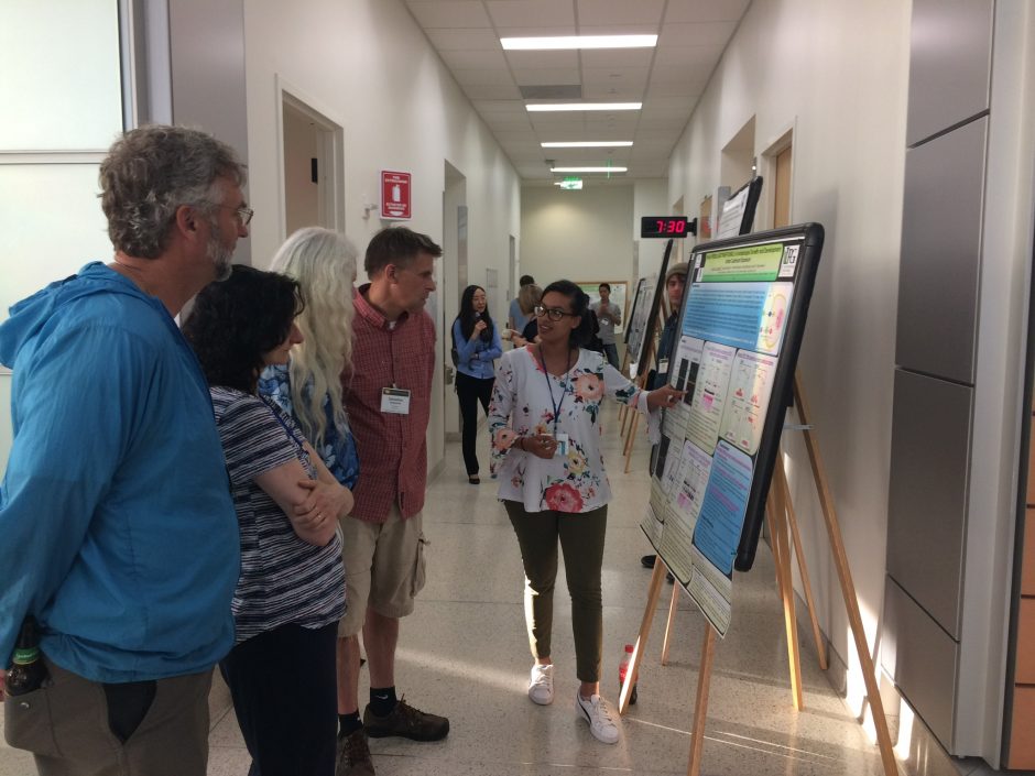 Lee-Ann explaining her poster to conference organzers at 2018 Plant Cell Dynamics meeting