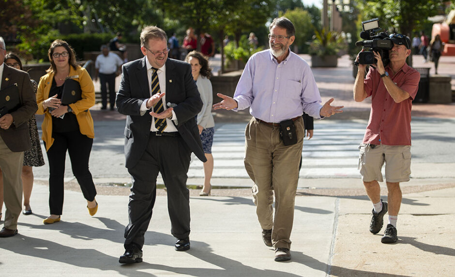 Chancellor Alexander Cartwright and George Smith share a laugh as they walk across campus