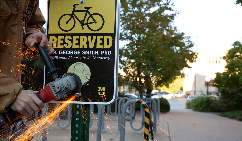 Campus facilities installs new reserved parking space sign to honor Nobel Laureate George P. Smith
