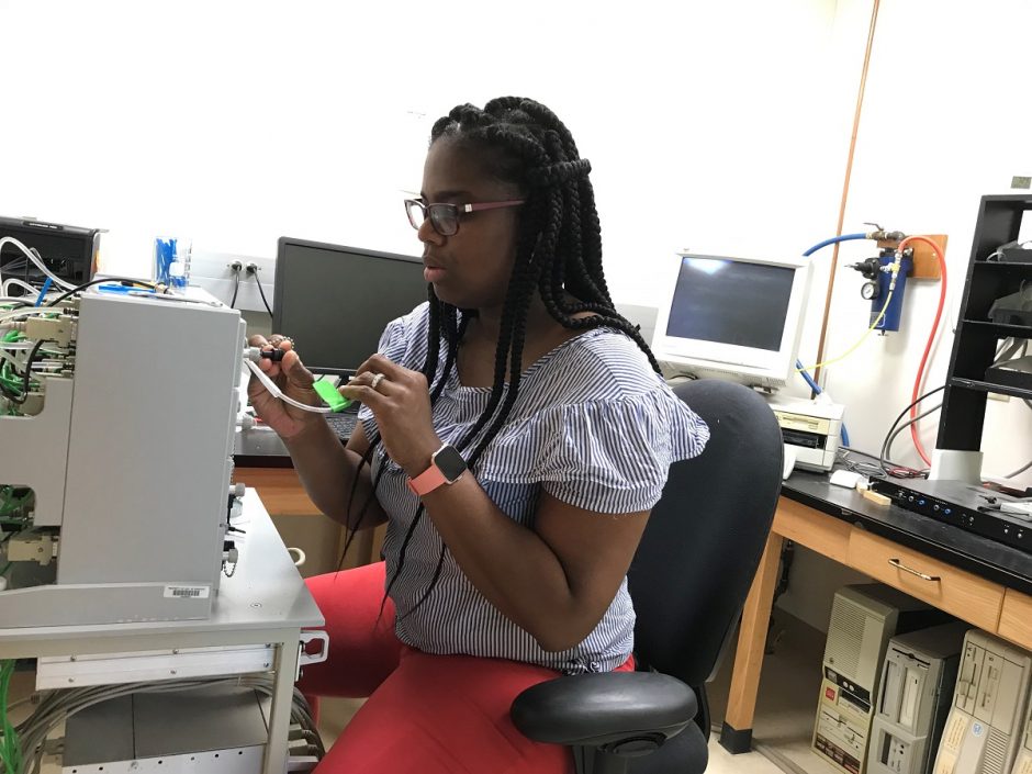 Patricka Williams-Simon, a doctoral fellow in biological sciences at MU who led the study, places fruit flies into a box to study how well they learn and remember. She and the team discovered some fruit flies learn better than others.