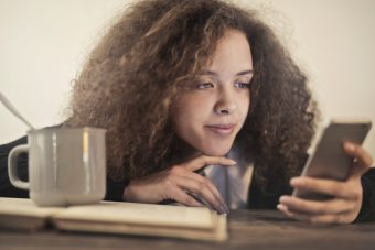 woman-in-black-shirt-leaning-on-brown-wooden-table