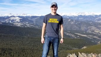 student standing in front of mountains