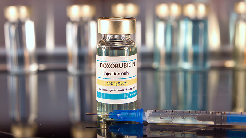 Vial of Doxorubicin and syringe on a stainless steel background
