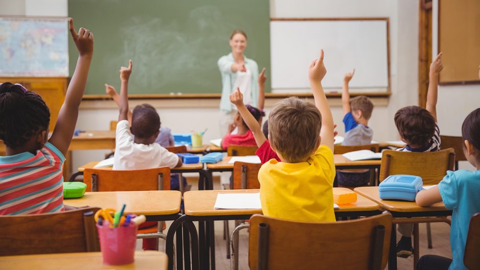 students raising their hands during class