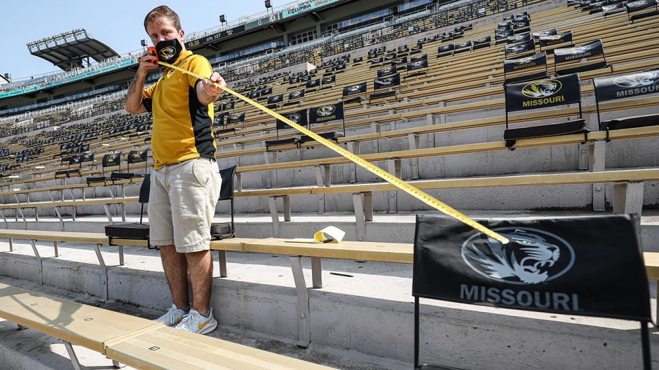 Man measuring distance of seats in Memorial Stadium