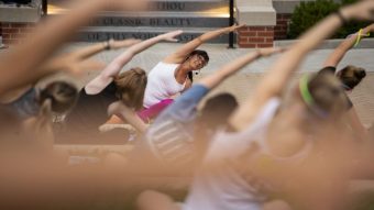 Student Affairs staff member, Andrea Kimura, leads a yoga class at Traditions Plaza in 2018.