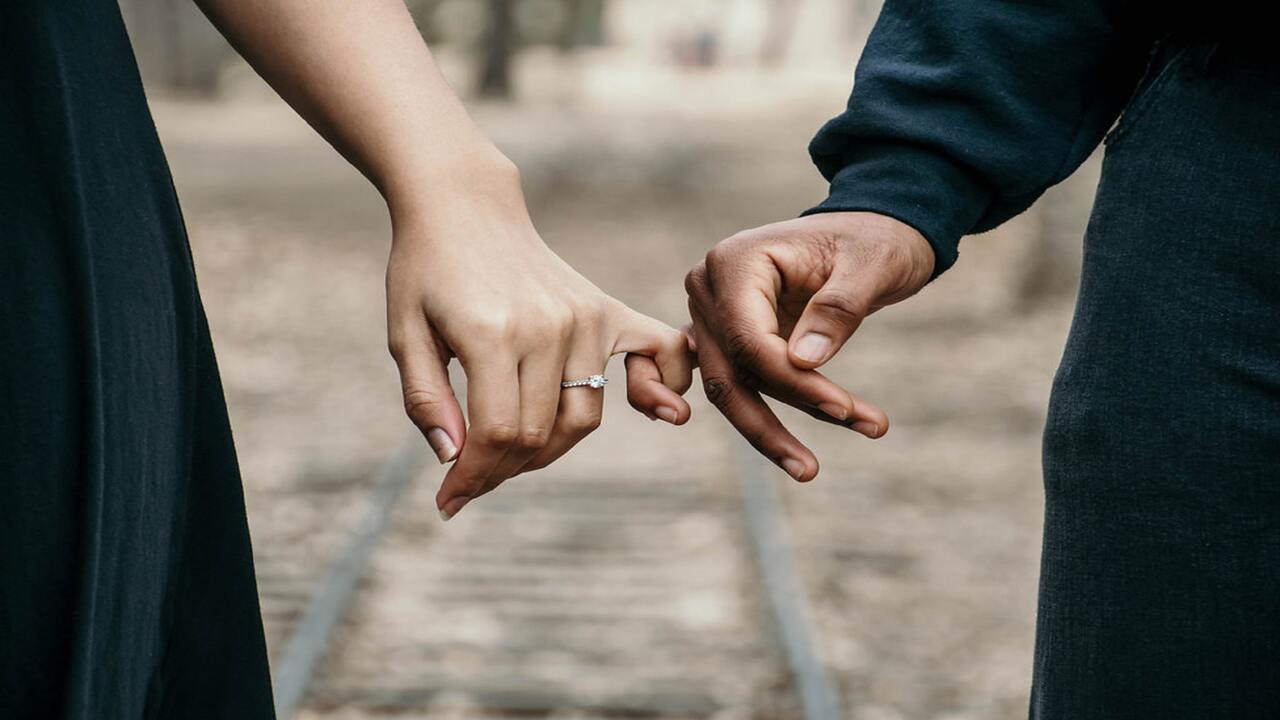 This is an image of an engaged couple holding hands.