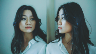 This is an image of a woman looking at herself in the mirror.