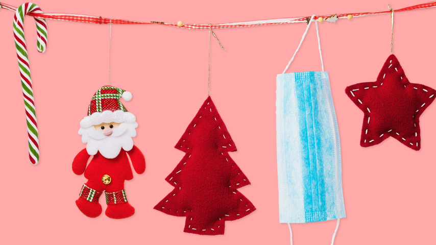pink background with a garland that has a candy cane, santa, tree, face covering and star hanging off of it