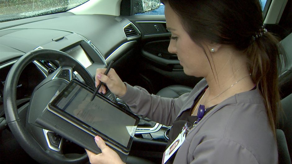 health care working woman on a tablet in her car