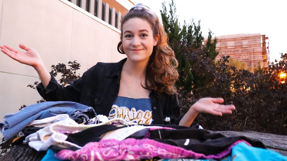 student posing with items from her clothing line