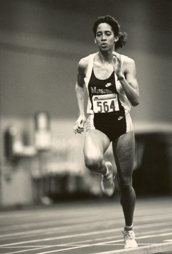 woman running track in a Mizzou uniform
