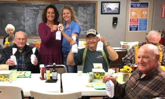 Aly Francis, standing at right, presents ground pork from her barrows to a senior center in Paris, Mo. Her efforts to curb food insecurity by donating pigs helped inspire Hogs for Hunger.