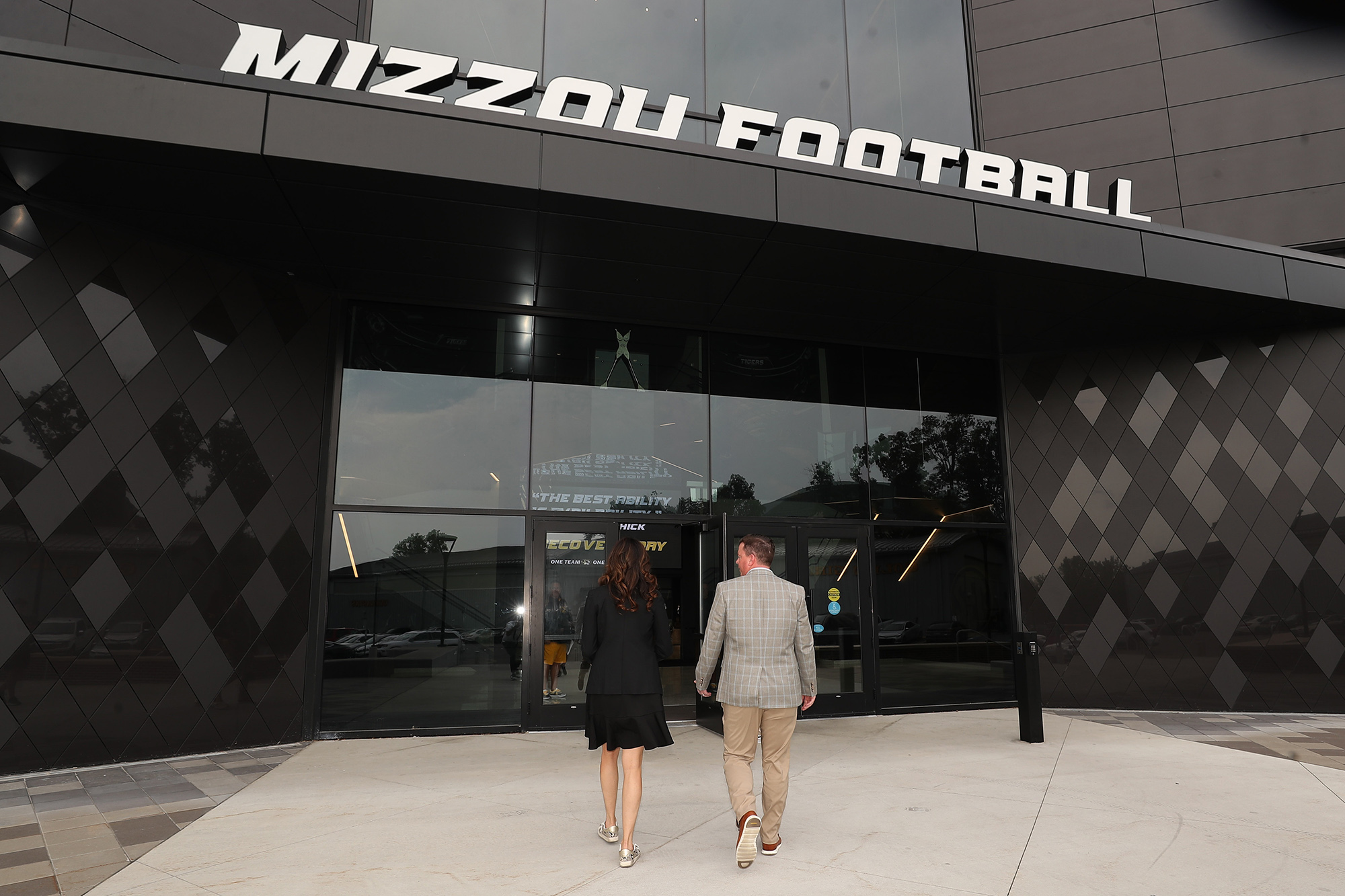 desiree reed-francois and a man walking into the football facility