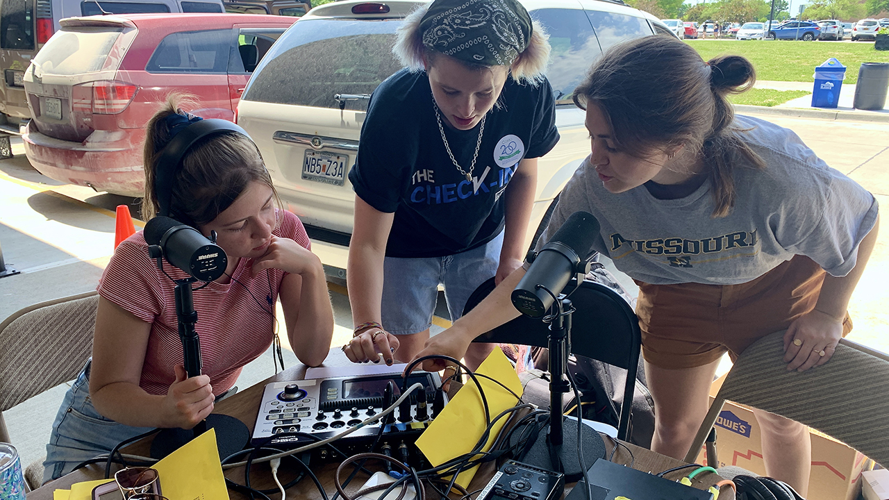 students work outside at an audio booth