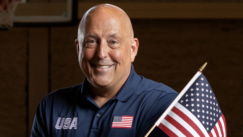 coach ron lykins in a team USA shirt with an american flag