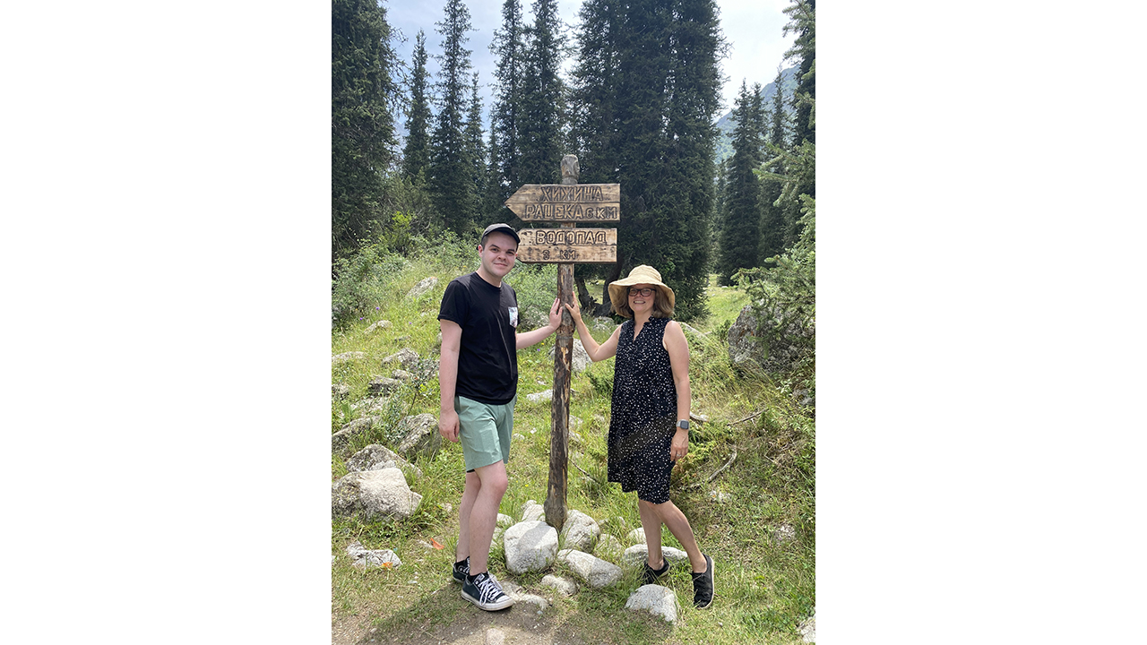 two people stand in the forest by a sign