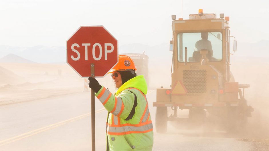 a woman with a stop sign in a work zone