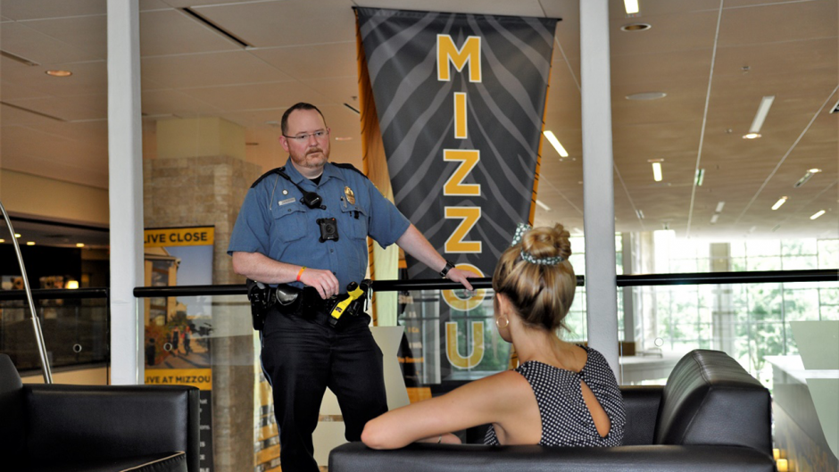 This is an image of a police officer talking to an adult.