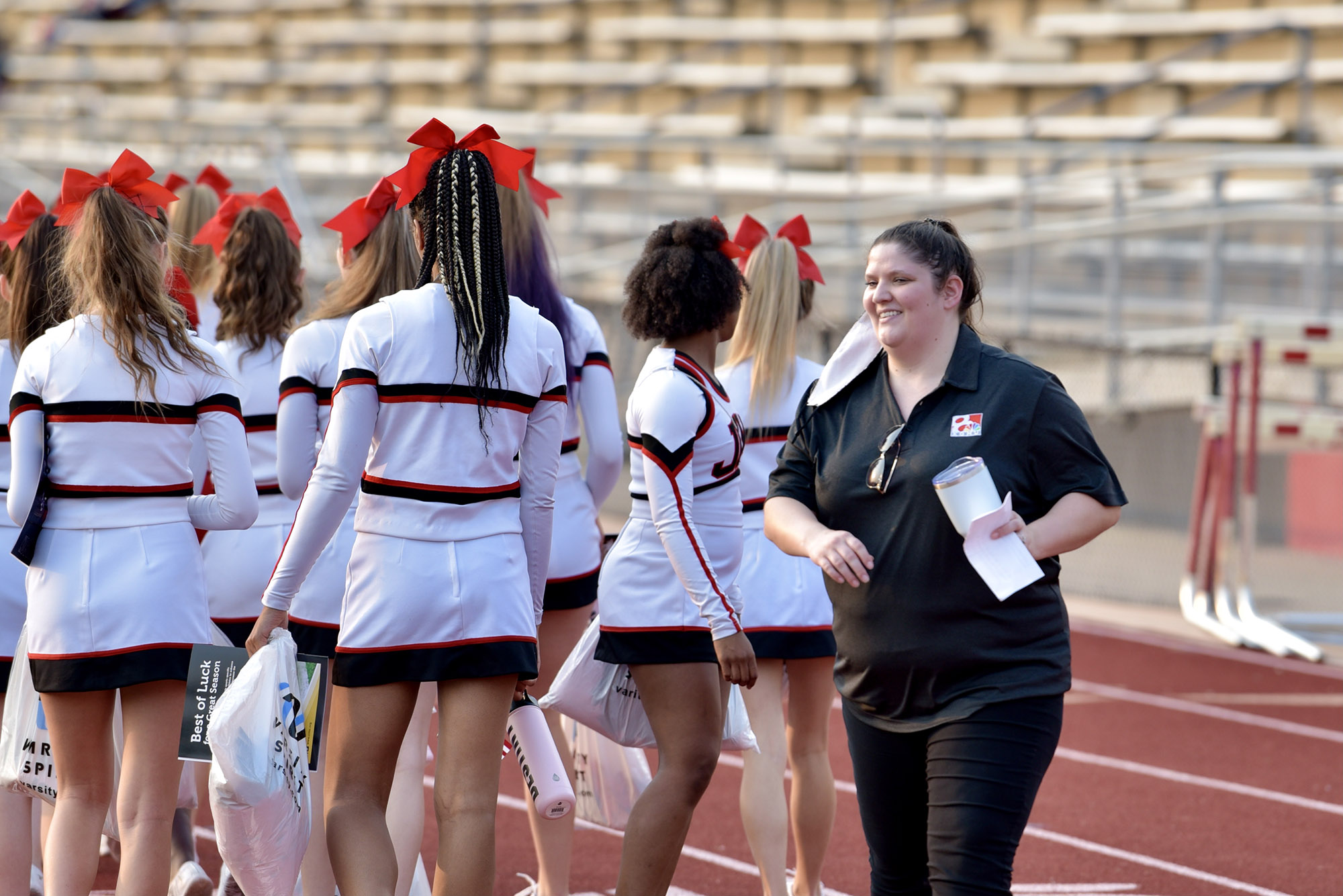 cheerleaders stand next to a woman