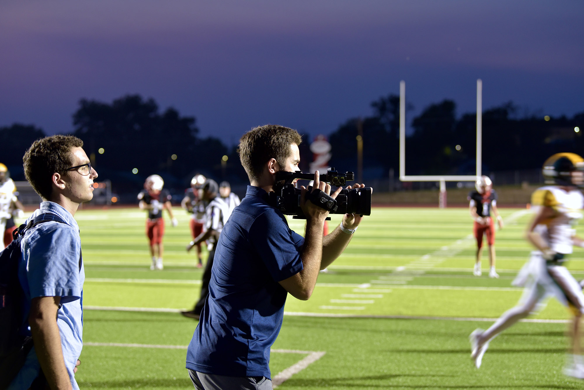 a student records video during a football game