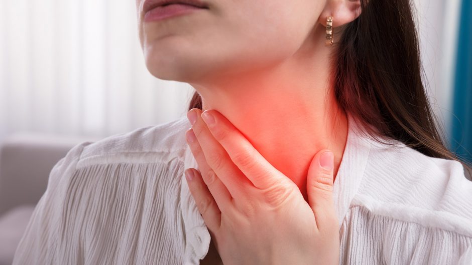 Close-up Of A Woman's Hand Touching Her Sore Throat. source: shutterstock