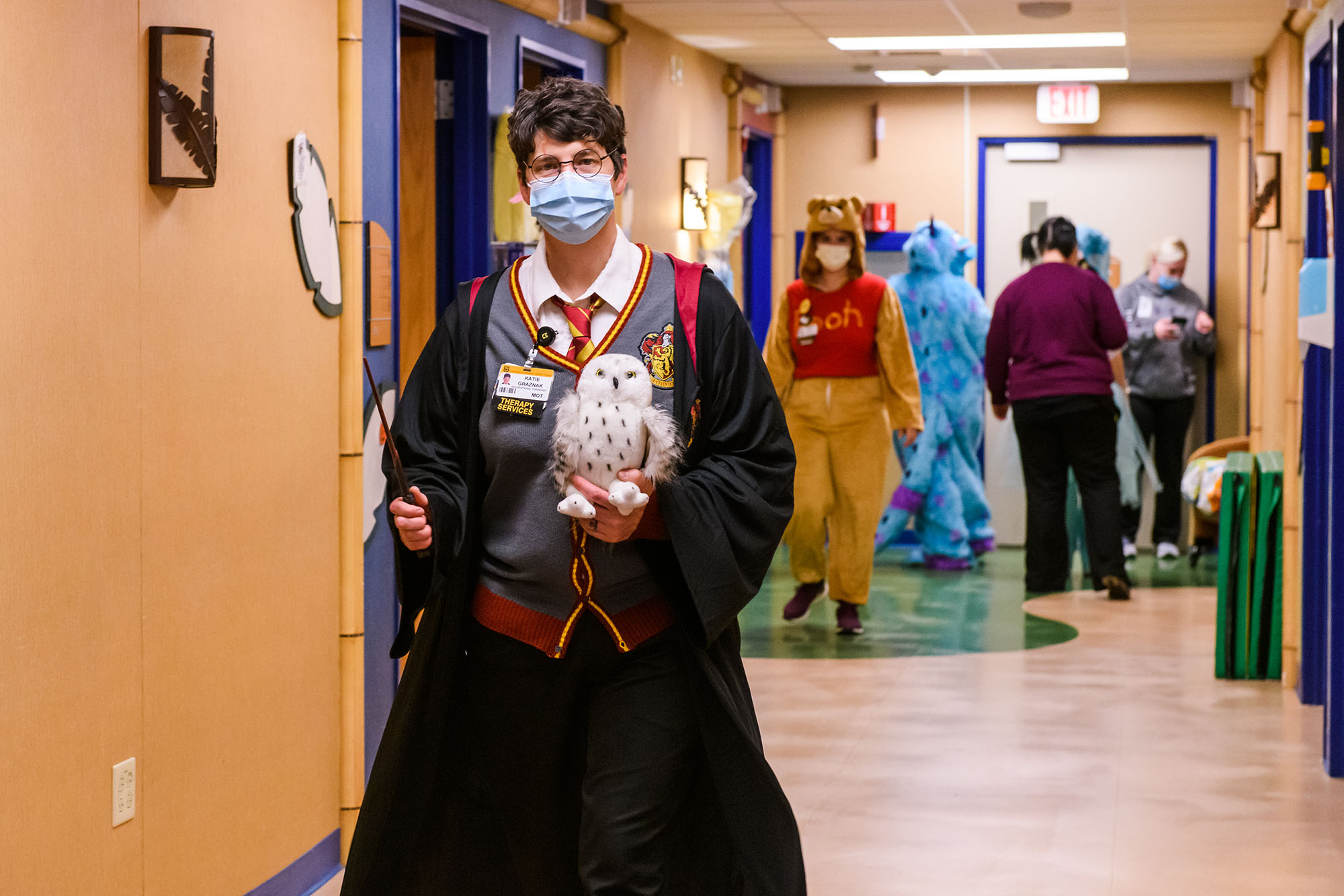 photo of a woman dressed as harry potter, walking down the hallway of mu children's hospital