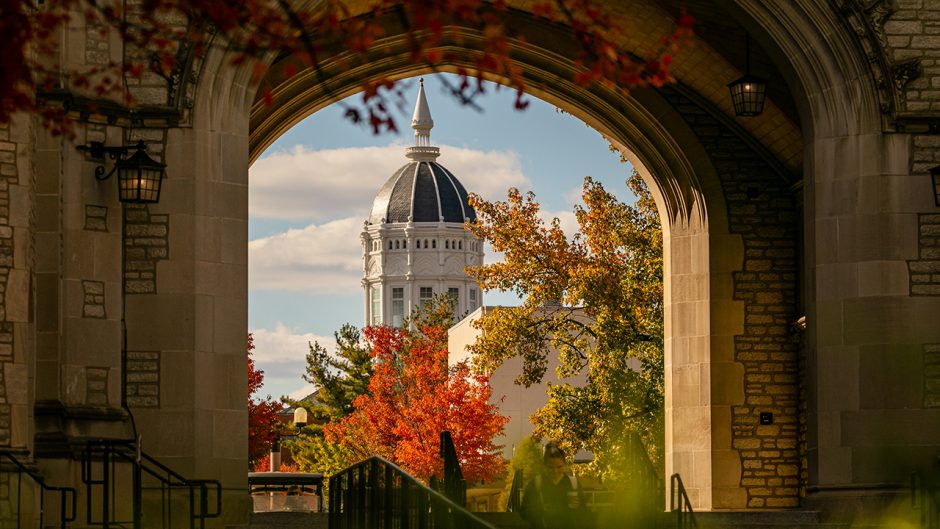 fall photo of jesse hall dome seen through the memorial union tower archyway