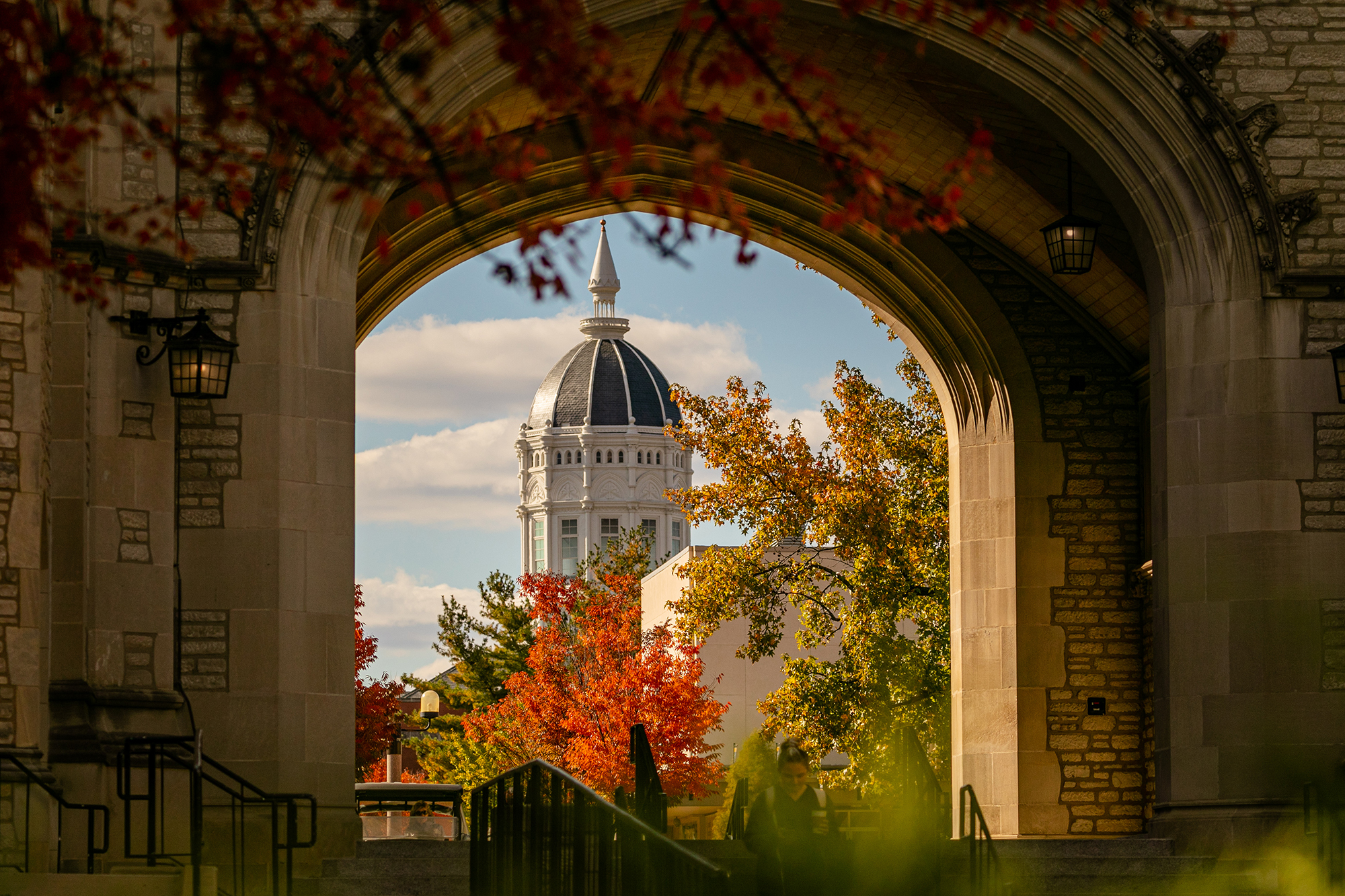 fall photo of jesse hall dome seen through the memorial union tower archyway