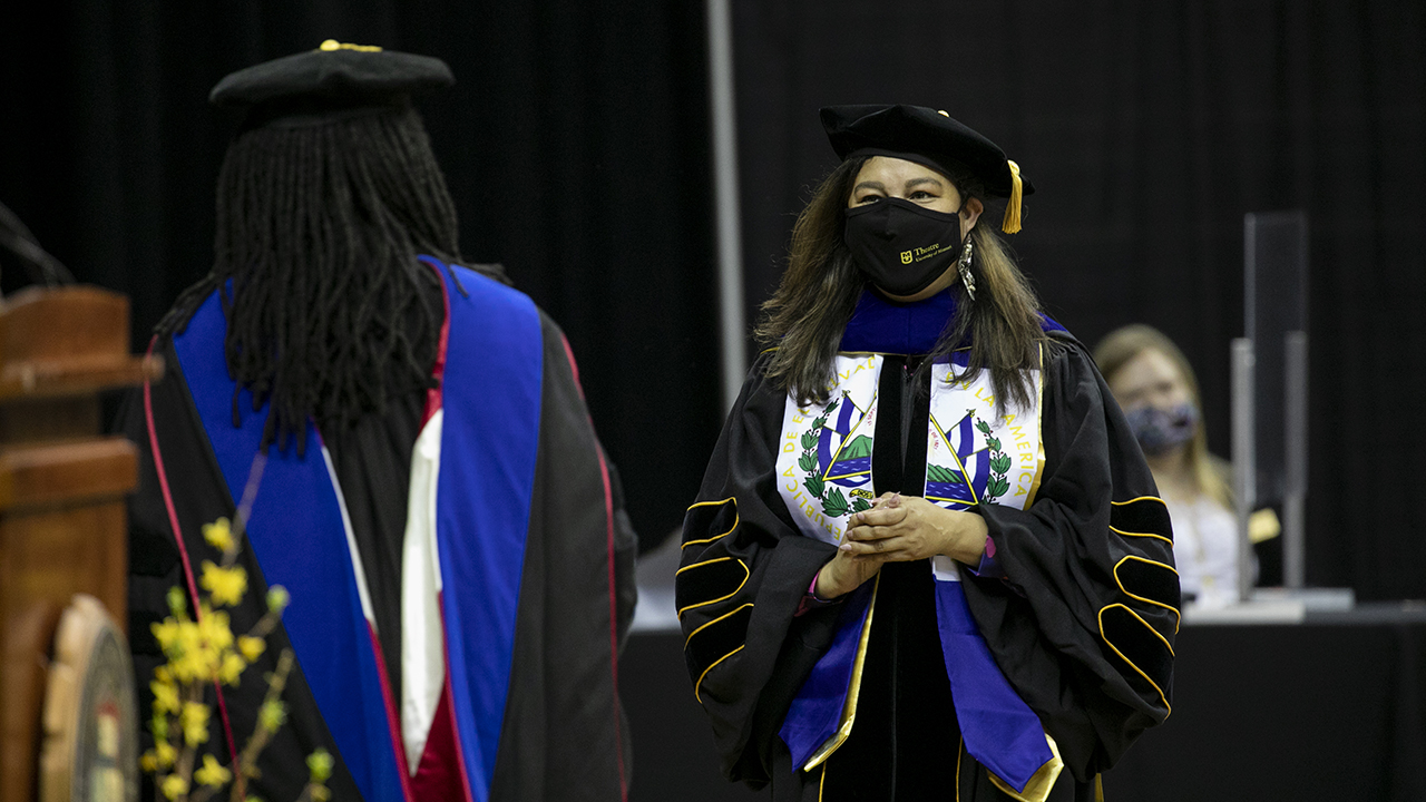 photo of two women in regalia at a commencement ceremony