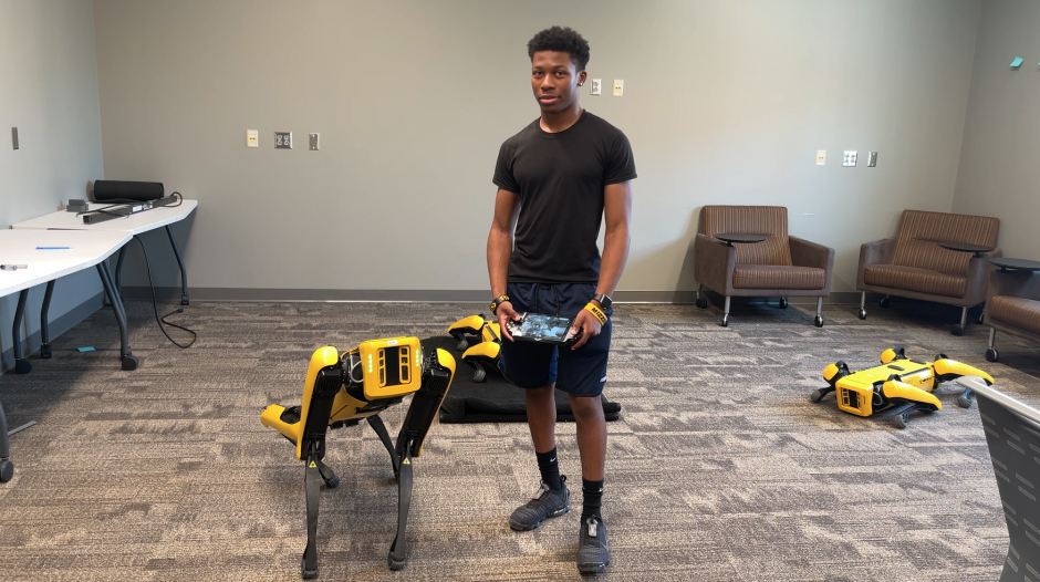 Trevontae Haughton stands by Spot the robotic dog