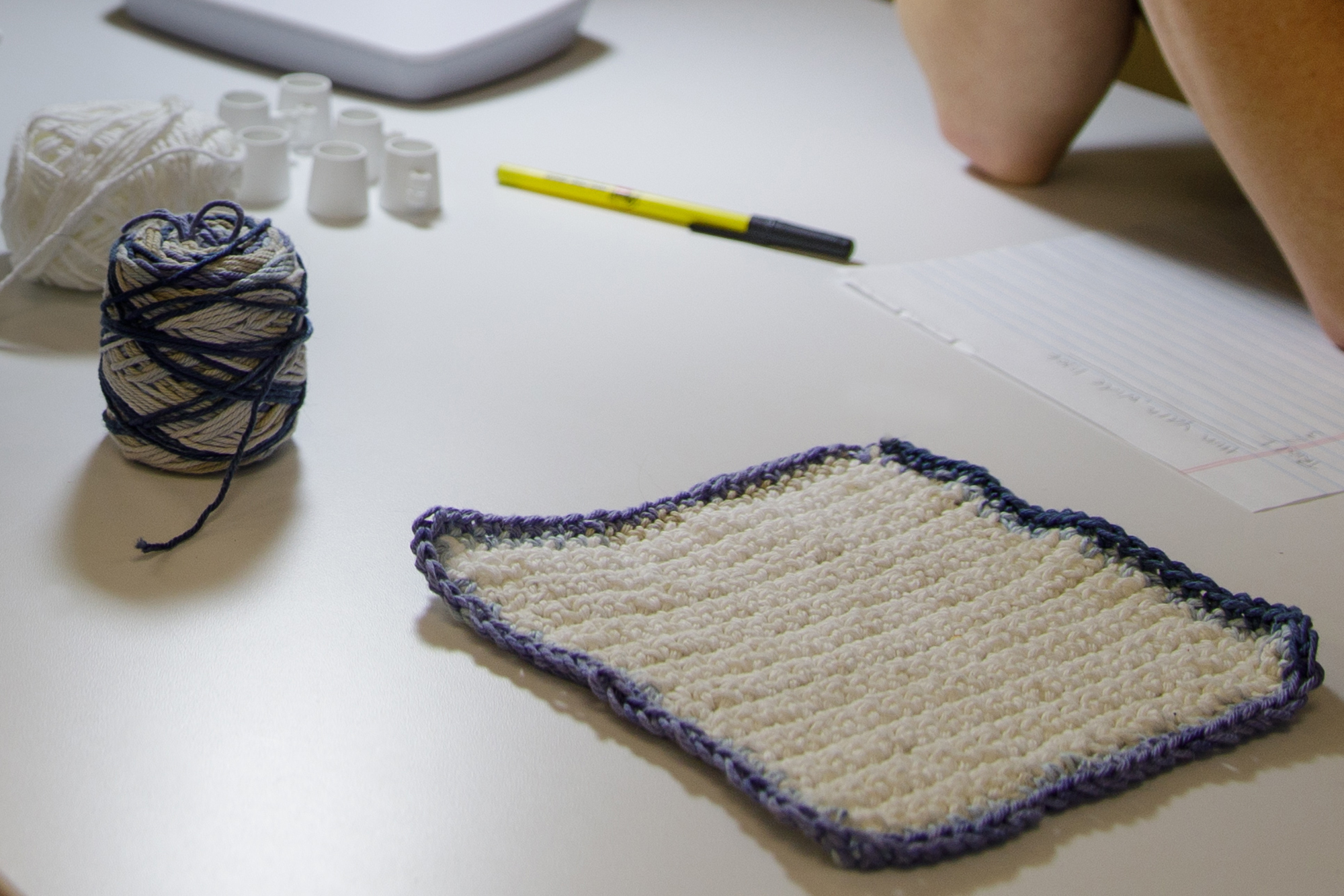 a crochet potholder sits on a table